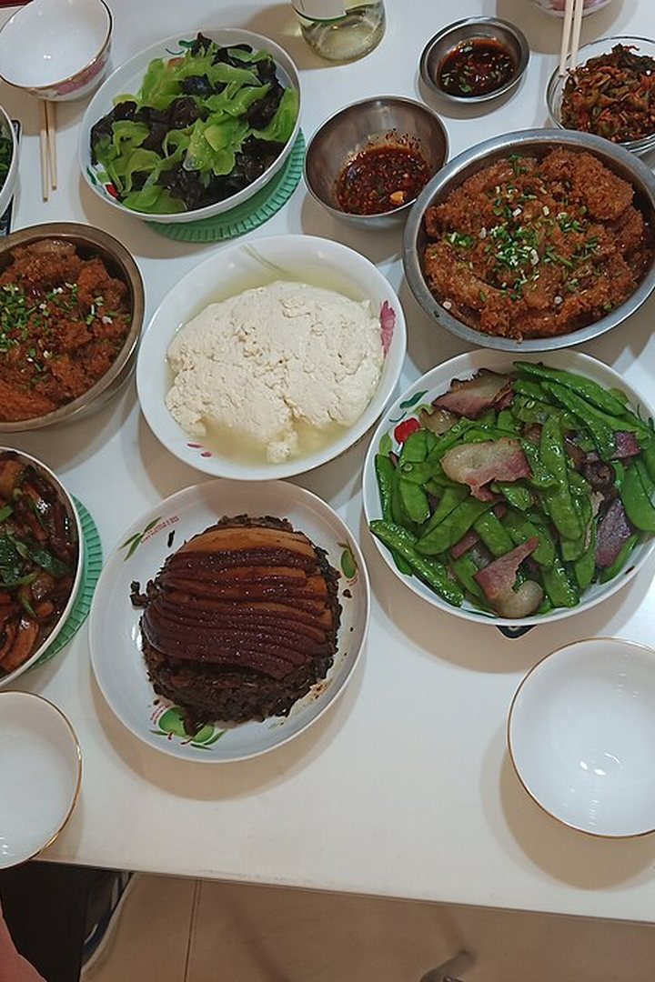 A table spread with sushi, pizza, tacos, paella, dumplings and more